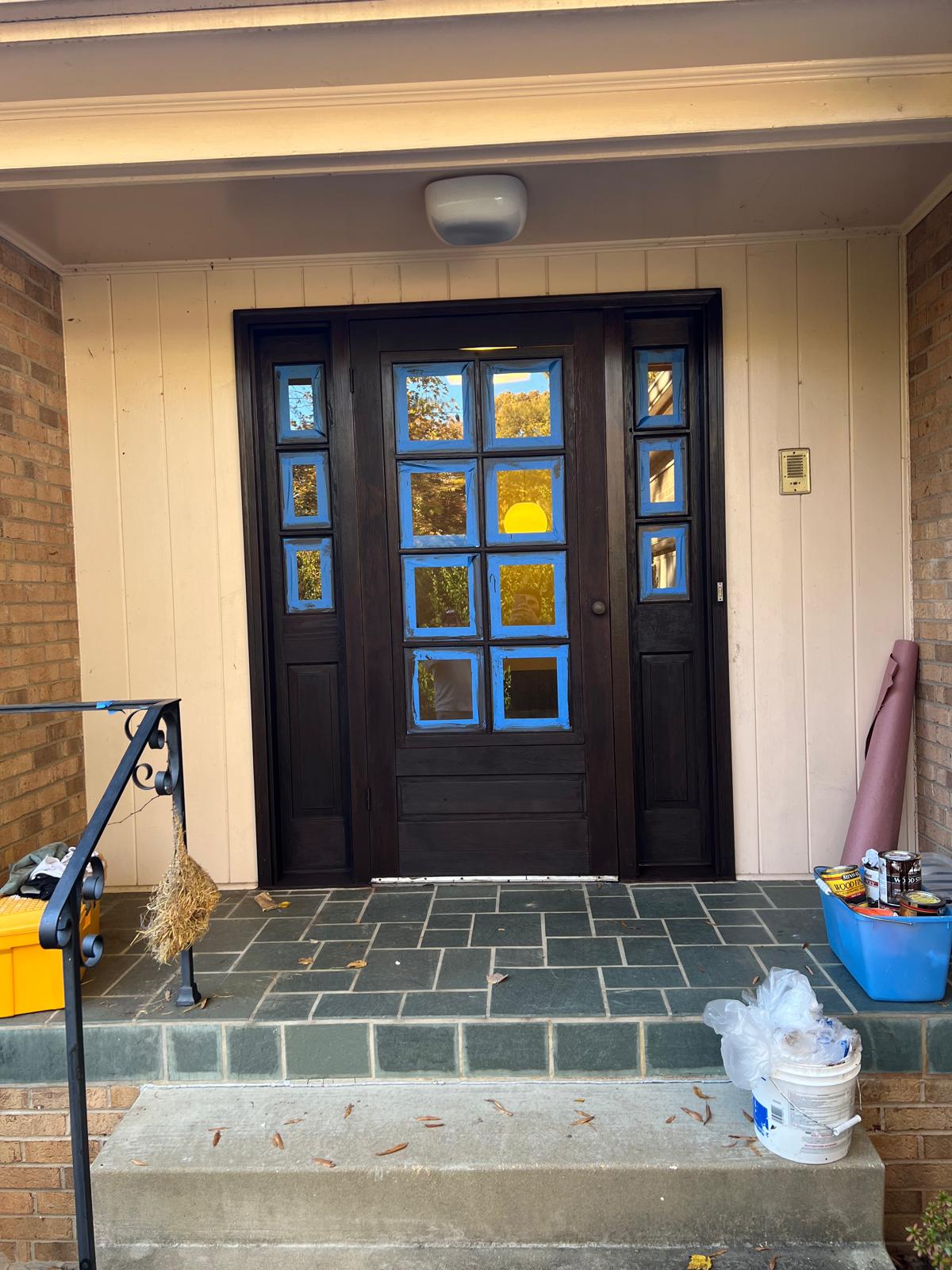 Entry door with protective tape during staining preparation.