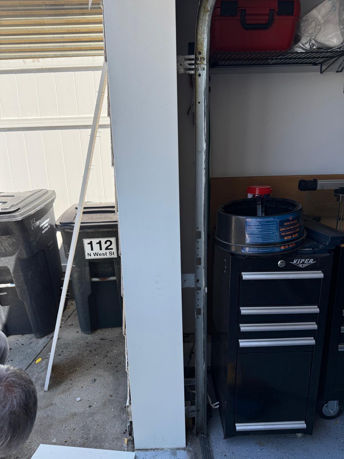White replacement trim covering the garage jamb during fitting.
