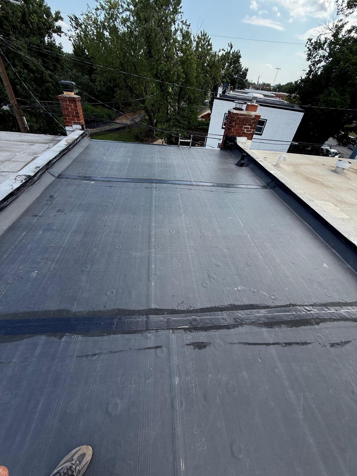 Dark roof surface viewed across the completed roof area.