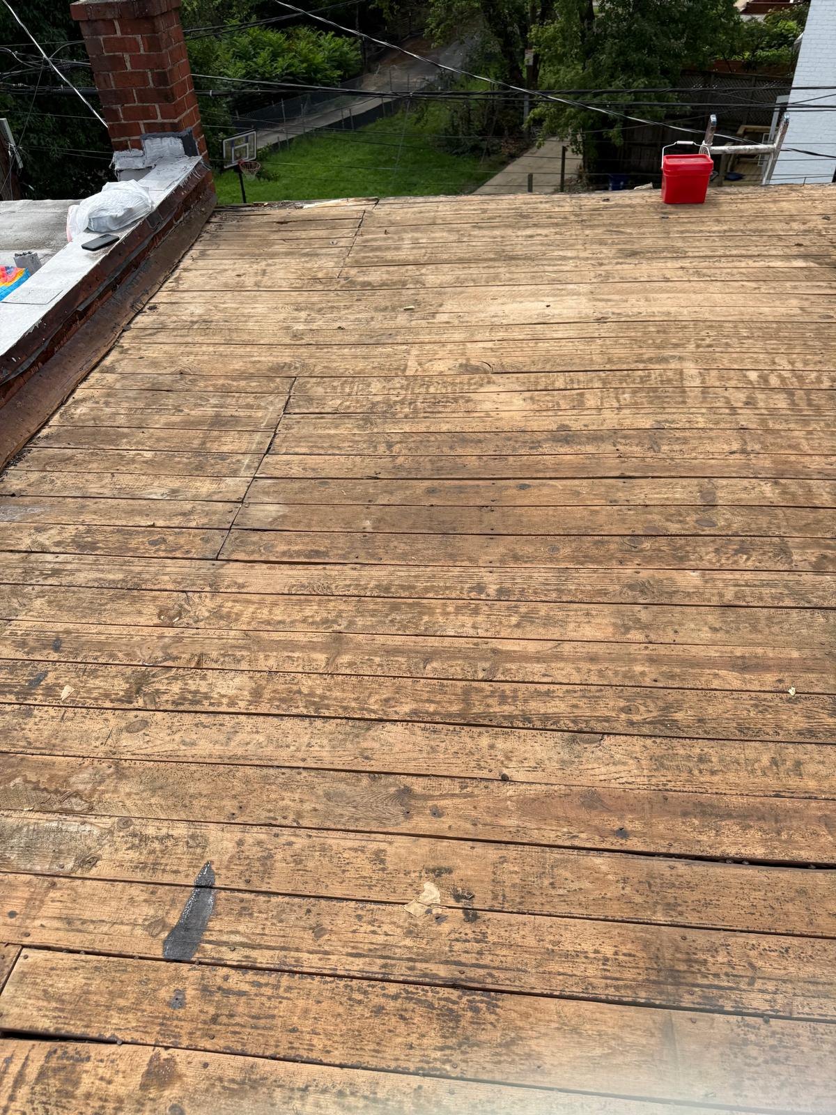 Exposed timber roof deck during replacement work.